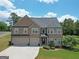 Elegant two-story brick home with manicured lawn, mature landscaping, and a two-car garage at 293 Ironwood Dr, Stockbridge, GA 30281