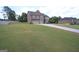 A view of the home with a sprawling front lawn and an extended driveway leading to the three-car garage at 293 Ironwood Dr, Stockbridge, GA 30281