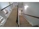 Hallway featuring a staircase with carpet and wood banisters connecting levels with elegance at 293 Ironwood Dr, Stockbridge, GA 30281