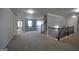 Spacious loft area with neutral walls, plush carpeting, and an elegant staircase with a decorative iron railing at 293 Ironwood Dr, Stockbridge, GA 30281