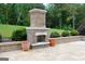 A beautiful outdoor stone fireplace nestled in a landscaped backyard with a charming patio area at 293 Ironwood Dr, Stockbridge, GA 30281