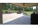 Covered outdoor patio with stone fireplace, ceiling fan, and comfortable seating overlooking lush greenery at 293 Ironwood Dr, Stockbridge, GA 30281