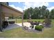 The covered patio features an outdoor fireplace, gas grill, hot tub, and a manicured lawn at 293 Ironwood Dr, Stockbridge, GA 30281