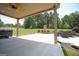Covered patio with a ceiling fan and an outdoor fireplace sits next to a meticulously maintained lawn at 293 Ironwood Dr, Stockbridge, GA 30281