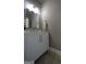 This updated powder room has a white vanity with brass hardware, stylish fixtures and a decorative mirror at 293 Ironwood Dr, Stockbridge, GA 30281
