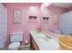 Bright pink bathroom featuring a sink, toilet, and a large mirror for a clean and refreshing space at 44 Twiggs Cor, Peachtree City, GA 30269