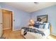 Bedroom with blue walls, carpeted floors, decorated with a comfortable bed and decorative artwork at 44 Twiggs Cor, Peachtree City, GA 30269