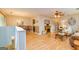Open-concept living room features light wood floors, fireplace, ceiling fan, dining area, and neutral color palette at 44 Twiggs Cor, Peachtree City, GA 30269