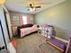 This carpeted bedroom features a window with pink curtains, and gymnast rings at 3014 Bowdon Tyus Rd, Bowdon, GA 30108