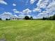 Sprawling ranch on lush, green land with a long driveway under a beautiful blue and cloudy sky at 3014 Bowdon Tyus Rd, Bowdon, GA 30108