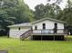 Back exterior of home features a spacious wooden deck with railing, offering views of the green backyard at 616 Inman Rd # B, Fayetteville, GA 30215