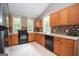 The kitchen has oak cabinets, black appliances, a tiled backsplash, and white tile flooring at 616 Inman Rd # B, Fayetteville, GA 30215
