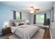 Stylishly staged main bedroom with hardwood floors, windows, ceiling fan, and neutral décor at 616 Inman Rd # B, Fayetteville, GA 30215