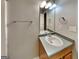 Bathroom with single sink vanity with wood cabinets and updated lighting fixture at 6630 Pole Creek Dr, Lithonia, GA 30058