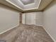Carpeted primary bedroom with tray ceiling and neutral walls at 6630 Pole Creek Dr, Lithonia, GA 30058