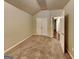 Neutral bedroom with textured carpet, vaulted ceiling, and double closet; open doorway to adjacent room at 6630 Pole Creek Dr, Lithonia, GA 30058