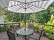 Back deck with patio table and chairs, covered by a striped umbrella, providing a serene outdoor seating area at 4147 Alayna Lee Cir, Mcdonough, GA 30252
