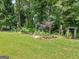 Scenic backyard with a lush lawn, stone-bordered garden, and assorted birdhouses and decorations at 4147 Alayna Lee Cir, Mcdonough, GA 30252