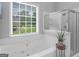 Relaxing bathroom with a soaking tub, a shower, and a large window showcasing a serene outdoor view at 4147 Alayna Lee Cir, Mcdonough, GA 30252