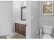 Cozy bathroom with dark wood vanity, a framed mirror and a toilet with storage at 4147 Alayna Lee Cir, Mcdonough, GA 30252
