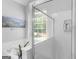 Bright bathroom featuring a modern shower, a soaking tub, and a window with a peaceful outdoor view at 4147 Alayna Lee Cir, Mcdonough, GA 30252