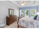 Well-lit bedroom with a blue accent wall, three windows, and wooden furniture for a comfortable atmosphere at 4147 Alayna Lee Cir, Mcdonough, GA 30252