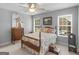 Bedroom with vintage wooden bed, two windows, and a dresser, complemented by a ceiling fan at 4147 Alayna Lee Cir, Mcdonough, GA 30252
