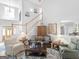 Cozy living room with a leather sofa, patterned rug, and staircase in a beautifully lit, open layout at 4147 Alayna Lee Cir, Mcdonough, GA 30252