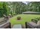 Spacious backyard with comfortable wicker furniture surrounding a fire pit, ideal for relaxation at 4187 Cherry Laurel Se Dr, Covington, GA 30014