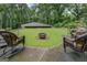 Expansive backyard with outdoor seating area and fire pit, surrounded by mature trees for added privacy at 4187 Cherry Laurel Se Dr, Covington, GA 30014
