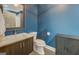 Bathroom showcasing blue walls, patterned floors, a mirror, and standard toilet features at 4187 Cherry Laurel Se Dr, Covington, GA 30014