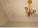 A detailed view of a vintage golden chandelier with crystal accents against a white ceiling at 4187 Cherry Laurel Se Dr, Covington, GA 30014