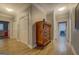 Hallway featuring wood-look flooring, vintage dresser, and multiple closets at 4187 Cherry Laurel Se Dr, Covington, GA 30014