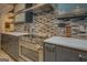 Close-up of a kitchen featuring a stainless steel range, sleek countertops, and mosaic tile backsplash at 4187 Cherry Laurel Se Dr, Covington, GA 30014