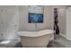 Slipper tub in primary bathroom with modern fixtures, artwork and walk-in closet at 4187 Cherry Laurel Se Dr, Covington, GA 30014