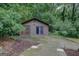 Exterior of the outbuilding, featuring wood paneling, double doors, and a well-maintained concrete driveway at 4187 Cherry Laurel Se Dr, Covington, GA 30014