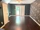 Bedroom with hardwood floors, sliding glass doors to backyard, and accent wall at 7813 Sugarland Dr, Jonesboro, GA 30236