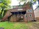 Spacious backyard showcasing a large deck, lush greenery, and exterior of the brick home at 823 Mountain View Run, Stone Mountain, GA 30087