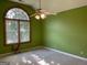 Spacious bedroom with a ceiling fan and a large window with an arched top, providing natural light at 823 Mountain View Run, Stone Mountain, GA 30087