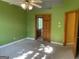 Bedroom with green walls, carpeted floors, a ceiling fan, and doorways leading to other rooms at 823 Mountain View Run, Stone Mountain, GA 30087