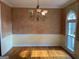 Traditional dining room features hardwood floors, decorative chandelier, and adjacent window with abundant natural light at 823 Mountain View Run, Stone Mountain, GA 30087