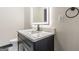 Bathroom with marble counter, dark vanity with gold hardware, and lighted mirror at 105 Robinwood Ct, Fayetteville, GA 30214