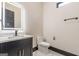 Modern powder room features a black vanity cabinet with quartz countertop, and marble-style tiled floors at 105 Robinwood Ct, Fayetteville, GA 30214