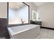 A luxurious modern bathroom with a soaking tub, frosted window and chic design at 105 Robinwood Ct, Fayetteville, GA 30214
