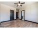 Bedroom with wood floor, ceiling fan, black door and base trim leading to bathroom at 105 Robinwood Ct, Fayetteville, GA 30214