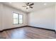 Spacious bedroom with a ceiling fan, hardwood floors, and a large window overlooking the backyard at 105 Robinwood Ct, Fayetteville, GA 30214