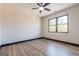 Bedroom with wood floor, ceiling fan, window with view of trees, and black base trim at 105 Robinwood Ct, Fayetteville, GA 30214