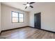 Bedroom with wood floor, window with view of trees, ceiling fan, and black door at 105 Robinwood Ct, Fayetteville, GA 30214