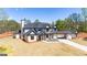Expansive two-story home boasting a black roof, sleek design, and long private driveway at 105 Robinwood Ct, Fayetteville, GA 30214