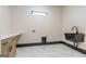 Well-lit laundry room featuring a modern sink, stylish cabinets, and attractive marble floors at 105 Robinwood Ct, Fayetteville, GA 30214
